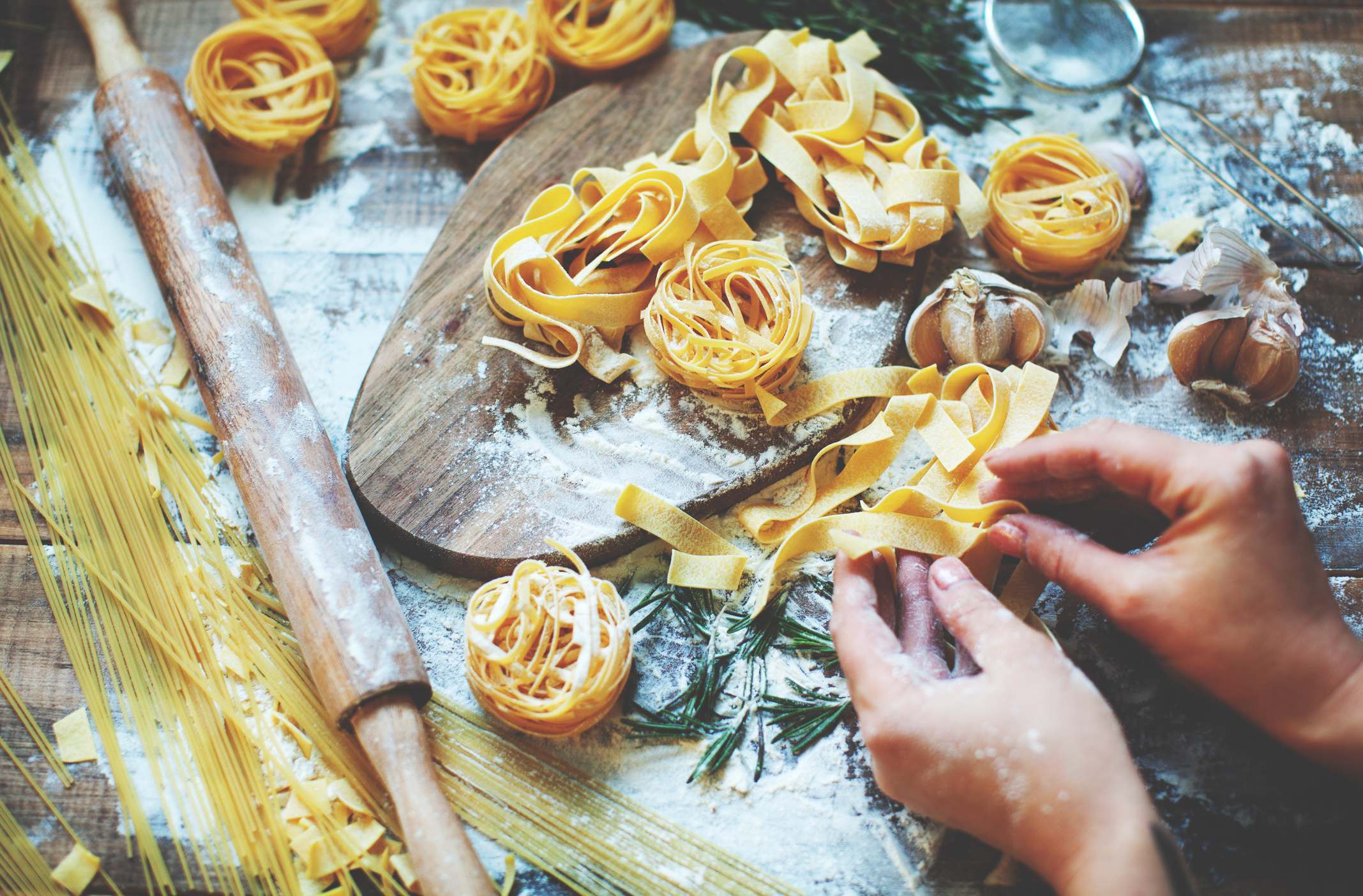 Someone rolling homemade pasta ribbons