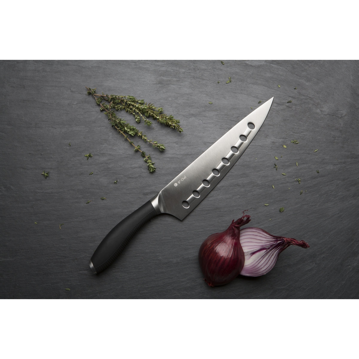 Circulon Chef's knife on a grey background with rosemary and sliced red onion.