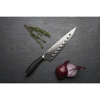 Circulon Chef's knife on a grey background with rosemary and sliced red onion.