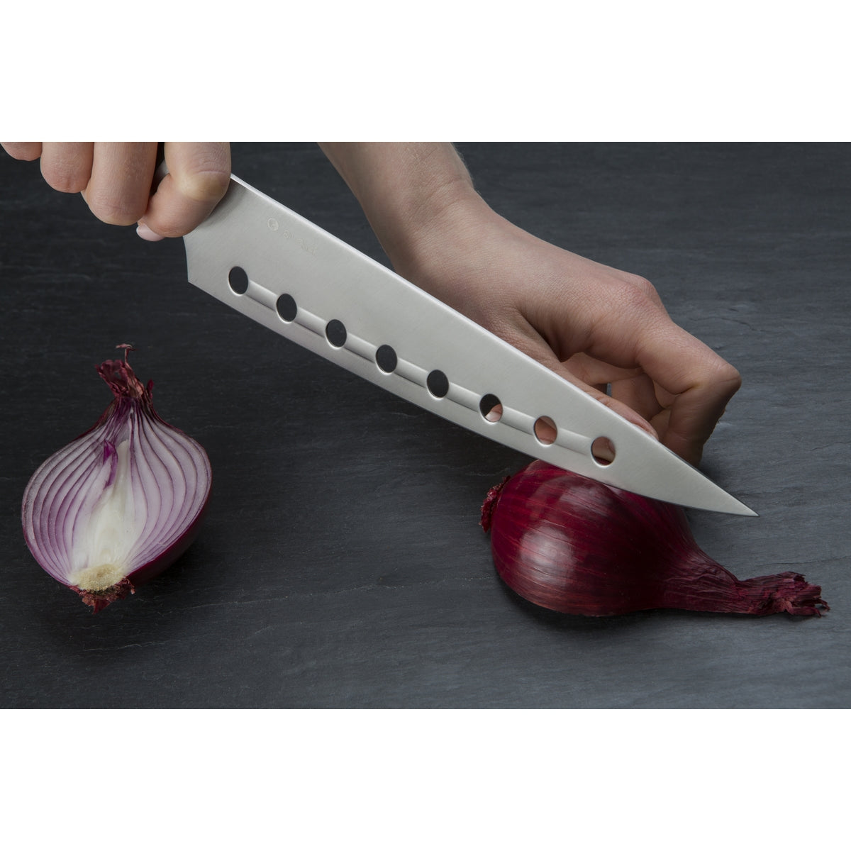 Person chopping red onion with the Circulon Chef's knife.