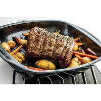 Non-stick roasting tray with beef and vegetables.