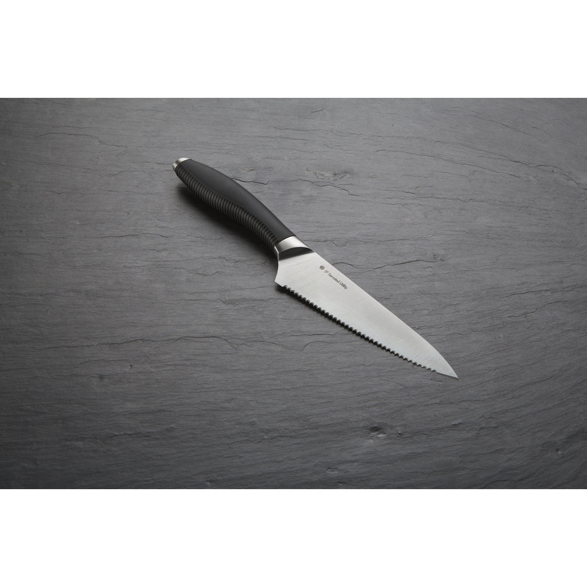 Image shows the serrated utility kitchen knife from Circulon on a grey background.
