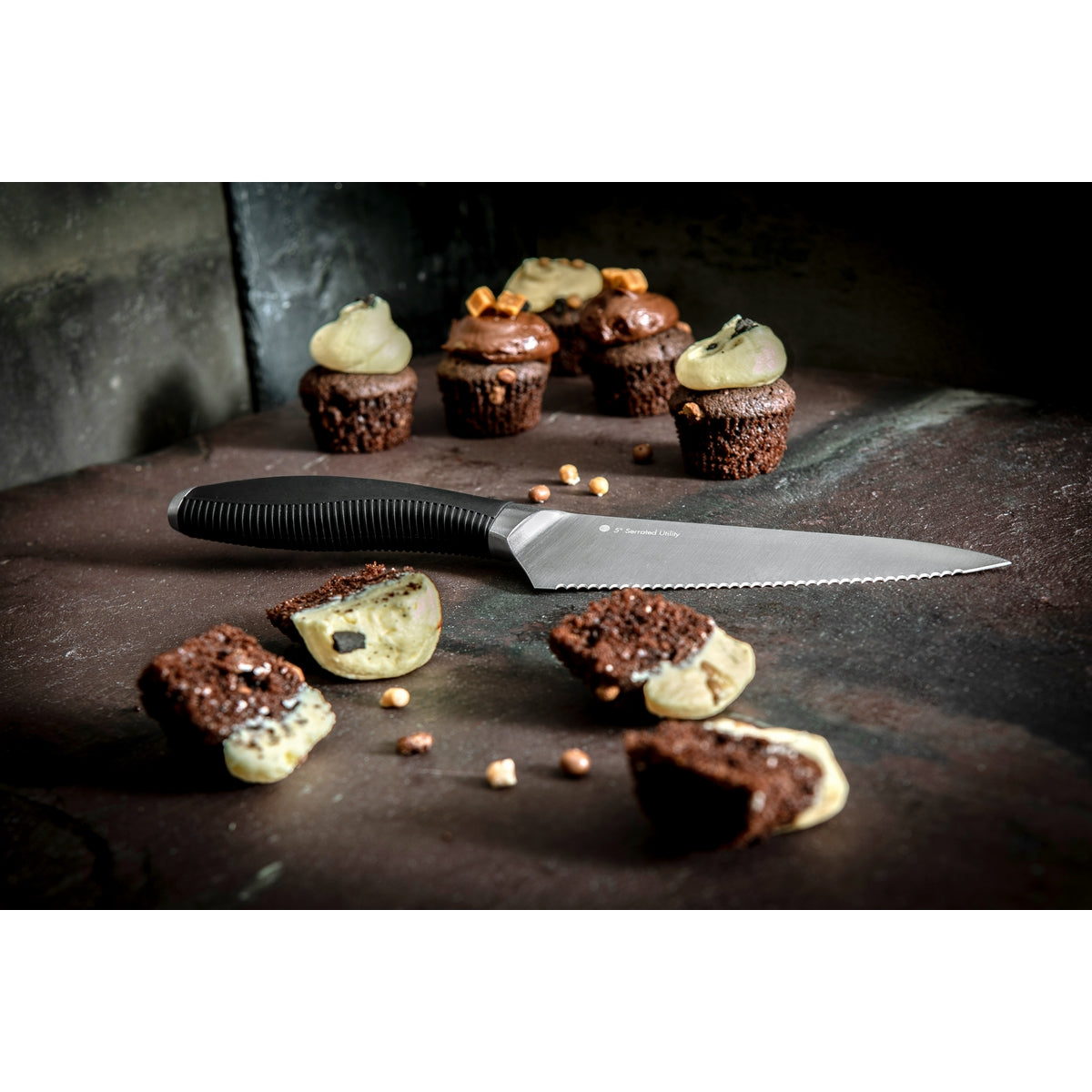 Image shows the seratted utility knife with sliced cupcakes. 