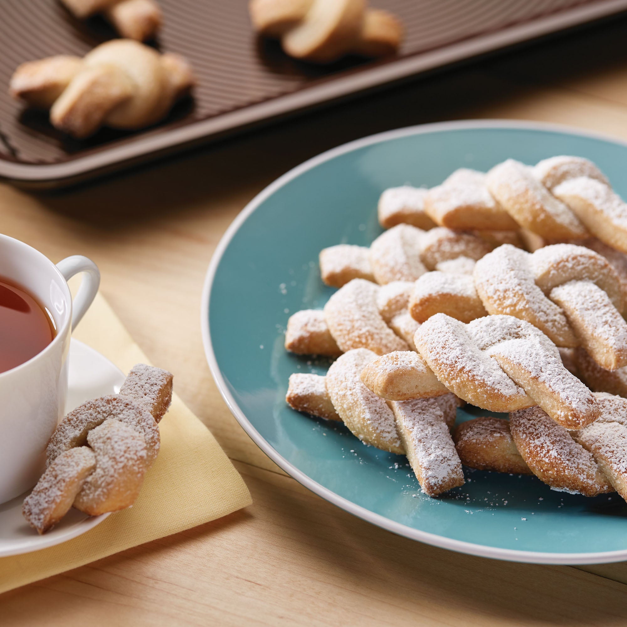 Knot cookies on a plate with tea